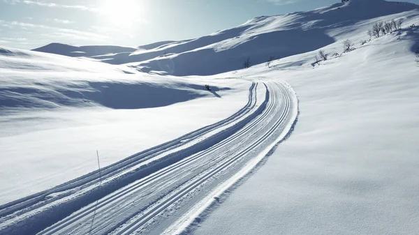 Narciarstwo biegowe stoku biegnącego przez oszałamiającą pokrytą śniegiem górę. — Zdjęcie stockowe