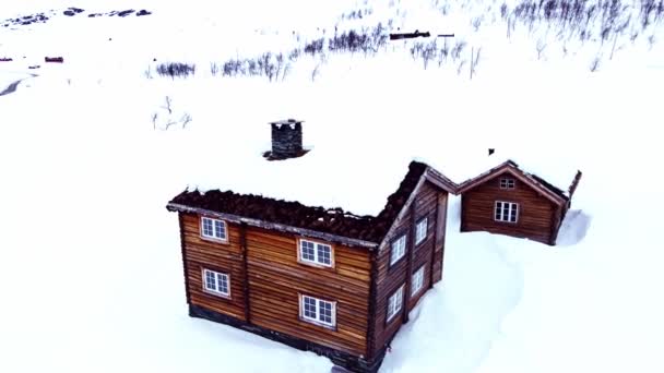 雪の寒い冬の日に山の中で伝統的な大規模な古典的なログキャビン 4K空中飛行 — ストック動画