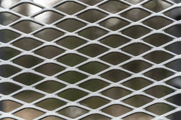 Metal mesh grid in weathered stained steel. Close up.