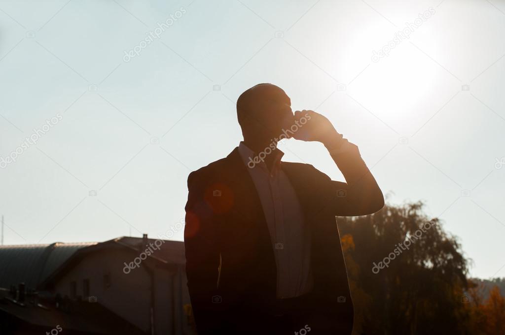 silhouette businessman with mobile phone walking 