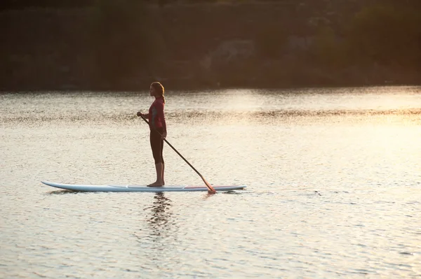 Silhouet van jong meisje paddle boarding bij sunset02 — Stockfoto