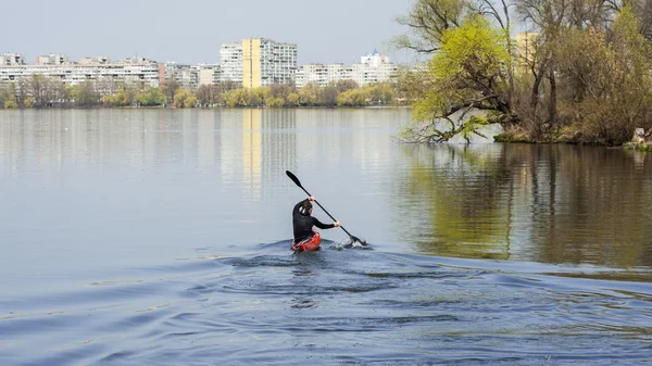 Un hombre kayak en un fondo de la ciudad, gire a kayak —  Fotos de Stock