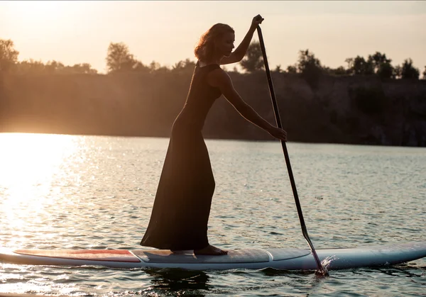 Silhueta de uma mulher bonita em stand up paddle board. SUP03 — Fotografia de Stock