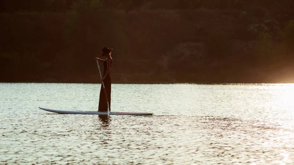 Silhueta de uma mulher bonita em stand up paddle board. SUP01 — Fotografia de Stock