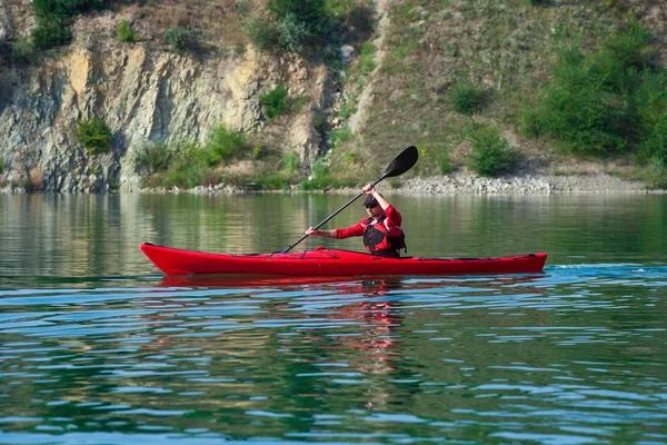 Hombre en un kayak rojo cerca de la orilla — Foto de Stock