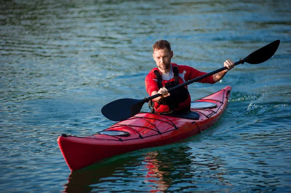 Homme athlétique dans les courses de kayak rouge — Photo