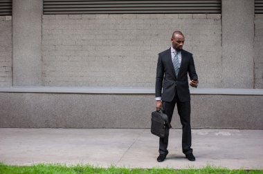 mutlu gülümseyen kentsel profesyonel adam akıllı telefon içinde kentsel kullanarak