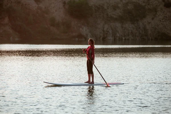 Silueta de niña paddle boarding al atardecer 11 — Foto de Stock