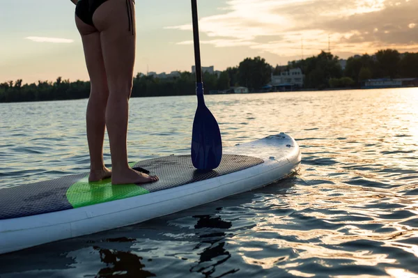 Sup sziluettje fiatal lány lapát beszállás: sunset13 — Stock Fotó