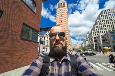 Genç mutlu gülümseyen adam traveler yapmak selfie üzerinde city03