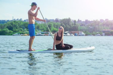 Genç çift kürek çekmeye sup board01 üzerinde gülümseyen