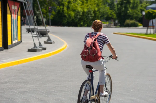 Красивая женщина в джинсах катается на велосипеде — стоковое фото