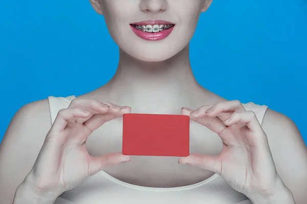 Hermosa chica con tirantes y tarjeta roja en las manos — Foto de Stock