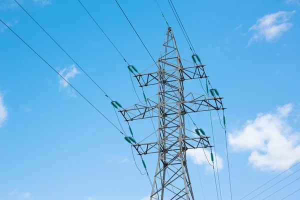 Transmissão de eletricidade pylonon azul céu fundo com nuvens — Fotografia de Stock