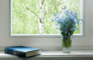 Kitap ve korun penceresinde buket