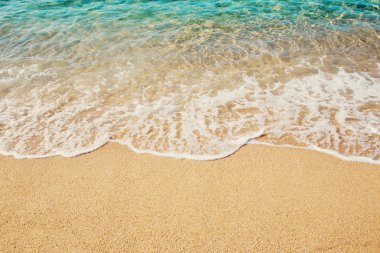 Arka plan dalga yumuşak kum plajındaki turkuaz denizin.