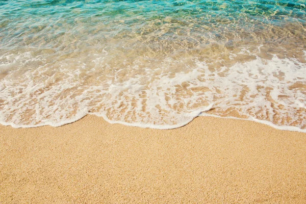 Arka plan dalga yumuşak kum plajındaki turkuaz denizin.