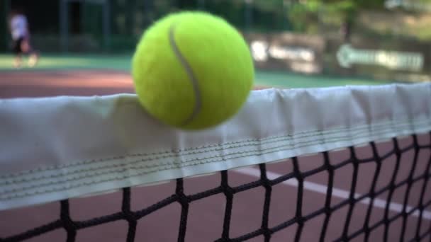 Желто-зеленый теннисный мяч застрял в сетке — стоковое видео