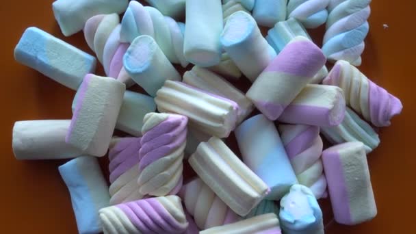 Tahta masa üzerinde dönen bir çok farklı kıvrımlı şekerlemenin üst görünümü — Stok video