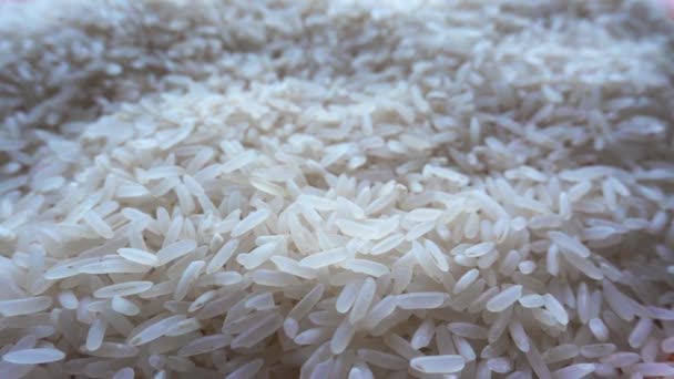 Witte rijstkorrels close-up. Stapel rijst. Voedselachtergrond. Natuur voedsel macro. Uitzoomen.. — Stockvideo