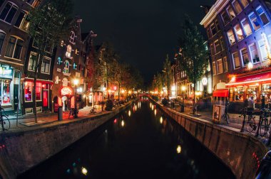 Amsterdam 'da De Wallen' ın genelev bölgesinde geceleri kahve dükkanları var. Kanal suyuna yansıyan kırmızı ve mavi ışıklar