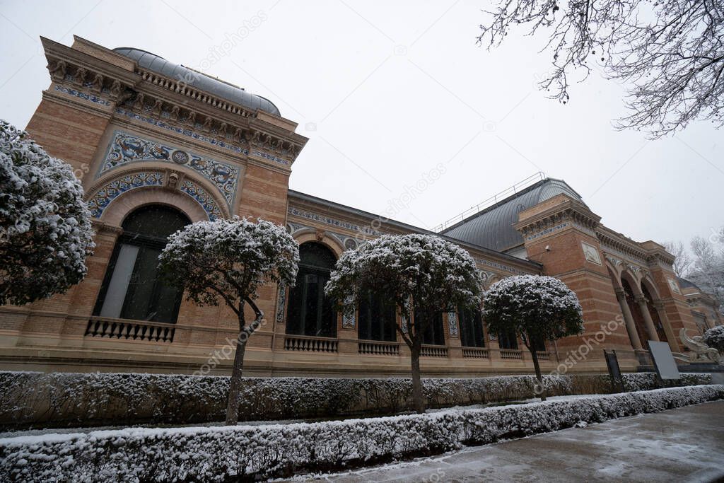Madrid, Spain - January 2021: Retiro Park in Madrid with snow after Filomena Storm strikes in the city. Velazquez Palace.