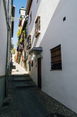 İspanya, Granada 'daki Yahudi sokağı, öğlen saatlerinde sert bir ışıkla. Eski binalar ve evler.