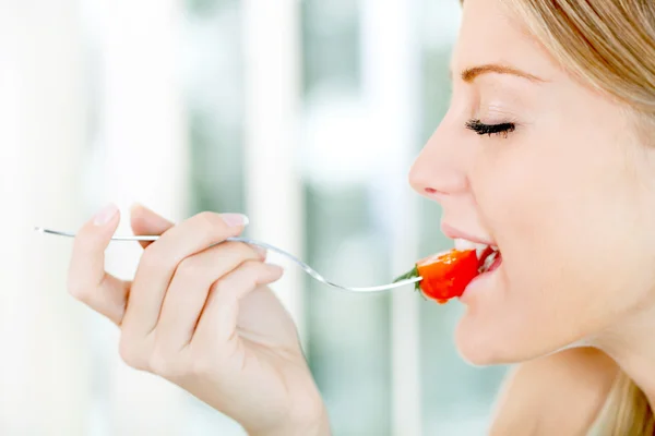 女人吃樱桃番茄 — 图库照片