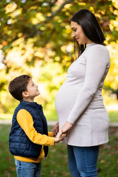 Menino Feliz Sua Mãe Grávida Estão Mãos Dadas Parque Outono — Fotografia de Stock