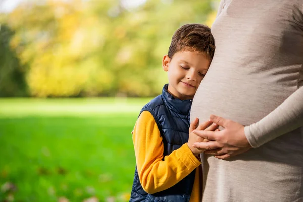 Junge Stützt Sich Herbst Park Auf Bauch Seiner Schwangeren Mutter — Stockfoto