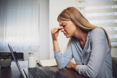 Genç bayan evden çalışıyor. Başı ağrıyor..