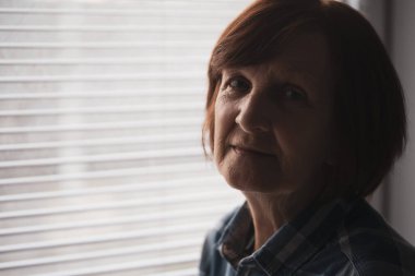 Üzücü bir şekilde kameraya bakan depresif yaşlı kadının portresi..