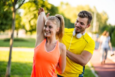 Genç çift dışarıda egzersiz yapıyor. Koşu için ısınıyorlar ve ısınıyorlar..