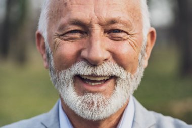 Mutlu son sınıf öğrencisinin portresi. Yaşlı adam gülümsüyor ve kameraya bakıyor..