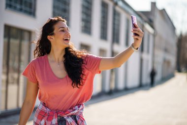Mutlu genç bayan güneşli bir günün tadını çıkarıyor..