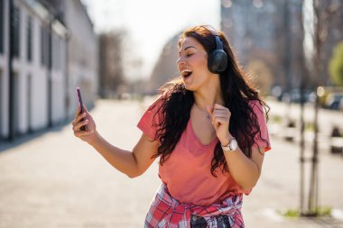 Mutlu genç bayan güneşli bir günün tadını çıkarıyor..