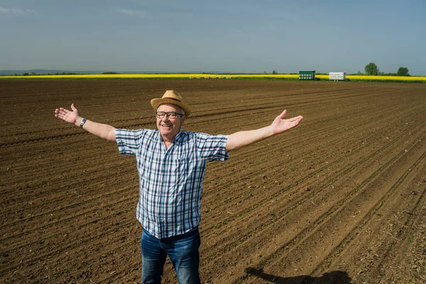 誇り高いシニア農家彼の播種トウモロコシ畑に立っている 彼は陽気で成功した播種を楽しんでいます — ストック写真