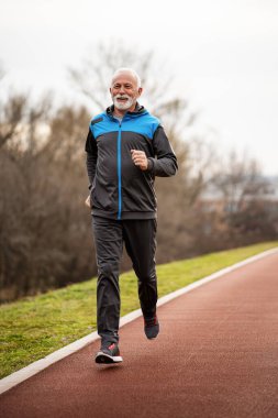 Aktif kıdemli adam koşuyor. Sağlıklı emeklilik yaşam tarzı.