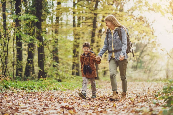幸せな母親と息子は森の中でハイキングをしている — ストック写真