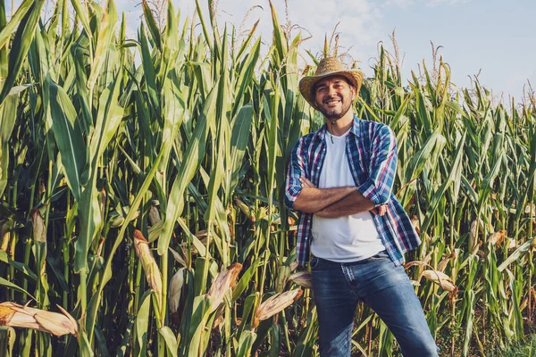 幸せな農家は彼の成長トウモロコシ畑によって誇らしげにポーズをとっています — ストック写真