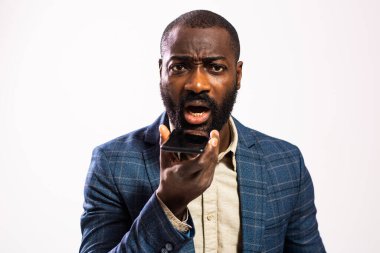 Sakallı, üzgün Afrikalı işadamı, bir telefon konuşması sırasında endişe ve gerginlik dile getiriyor..