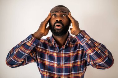 Duygusal olarak stresli, kafası karışmış ve şok olmuş kafasını kaldırıp yukarı bakan siyahi bir adamın portresi..