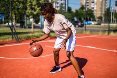 Afrikalı bayan basketbolcu tek başına antrenman yaparken salya sürme becerisi uyguluyor..
