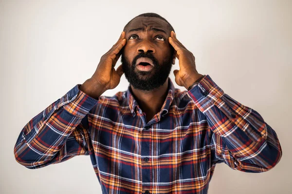 Duygusal olarak stresli, kafası karışmış ve şok olmuş kafasını kaldırıp yukarı bakan siyahi bir adamın portresi..