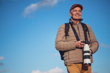Son sınıf öğrencisinin portresi, dışarıda duran fotoğraf meraklısı, doğada açık bir günün tadını çıkarıyor..