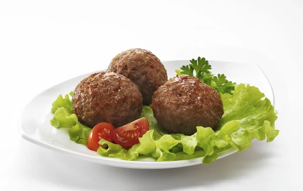 meatballs on white pate salad and tomatoes