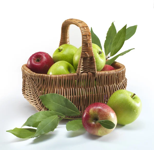 Fresh ripe Red and green apples in a basket on white background
