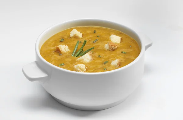 Green vegetables soup puree with croutons on a white background