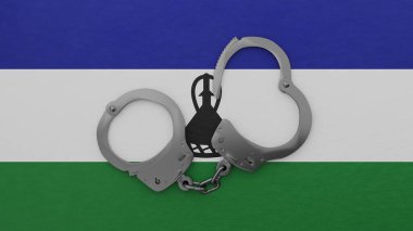 Yarı açık çelik kelepçe ortada ve Lesotho bayrağının üstünde.