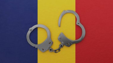 Yarı açık çelik kelepçeler ortada ve Romanya bayrağının tepesinde